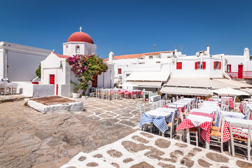 Wall Mural - Small square with Greek church and restaurants in old town of Mykonos, Greece.