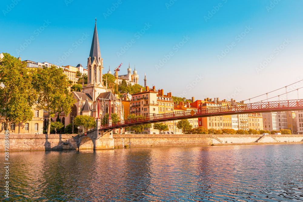 Early morning cityscape view of St Georges pedestrian bridge in Lyon city with old church on the opposite bank of the river. Travel destinations in France - obrazy, fototapety, plakaty 