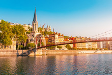 Early Morning Cityscape View Of St Georges Pedestrian Bridge In Lyon City With Old Church On The Opposite Bank Of The River. Travel Destinations In France