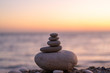 Perfect balance of stack of pebbles at seaside towards sunset. Concept of balance, harmony and meditation. Helping or supporting someone for growing or going higher up.