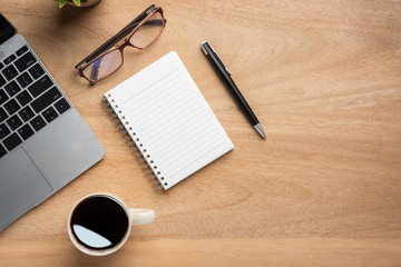 Aufkleber - Wooden office desk table with blank notebook, laptop computer, cup of black coffee and supplies. Top view with copy space, flat lay.