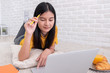 © weedezign - Asian woman lying on carpet and writing on notebook and learning on laptop with relax emotion at home,work at home concept.online learning