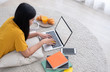 © weedezign - Asian female freelancer working on laptop computer at home.woman lying down on carpet at brick wall.working online lifestyle.mock up screen with clipping path