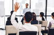 © Art_Photo - Businessman standing in front of group of people in consulting meeting conference seminar and showing hand to answer question at hall or seminar room.presentation and coaching concept