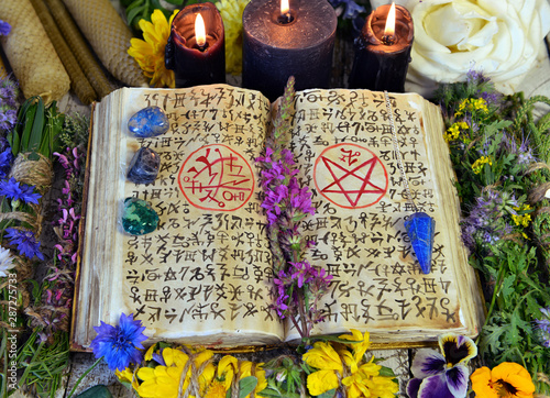 Witch Book With Spells And Symbols Black Candles Reiki Crystals And Flowers Stock Photo Adobe Stock