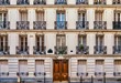 Street view of the elegant facade of an old Parisian apartment building. Vintage style photo.