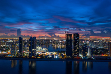 Wall Mural - Beautiful twilight aerial drone photo of an oceanfront city backlit by purple sunset