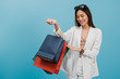 © bunditinay - Asian beautiful women blogger are shopping and holding shopping bag in blue color background with copy space.Concept of online shopping business with Promotion and Sale.