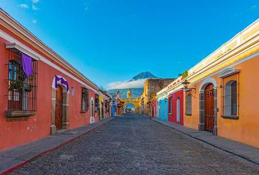 cityscape of the colorful main street of antigua city at sunrise with the famous yellow arch and the