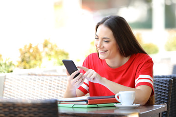 Sticker - Happy student in red browsing phone content in a bar