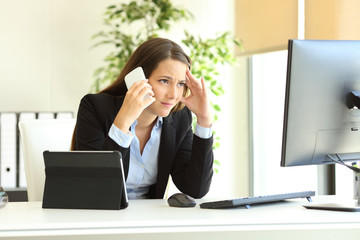 Wall Mural - Worried office worker using multiple devices calling on phone