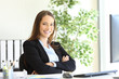 Happy businesswoman at office posing looking at you