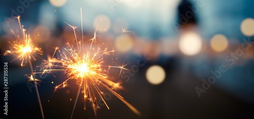 Fotomural Burning sparkler with bokeh light background