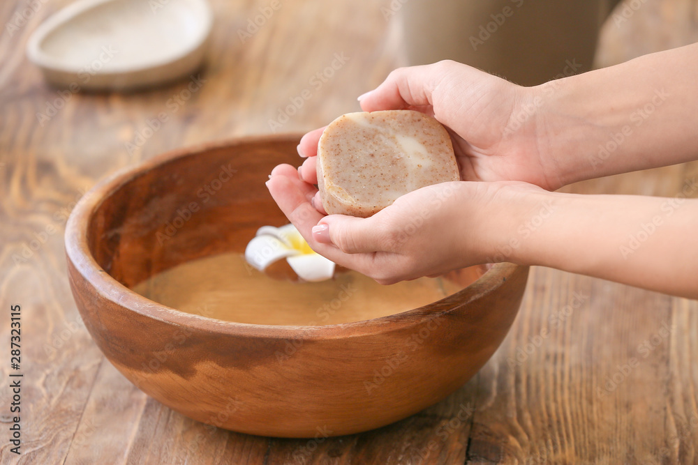Woman washing hands with soap in bathroom