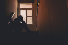 Silhouette Sad Young Man Sitting At The Stairs In The Dark, Depression And Anxiety Disorder Concept, Life Problems, Illness,Sadness, Despair, Dark..