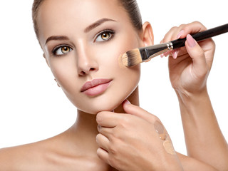 Wall Mural - makeup artist applying liquid tonal foundation on the face