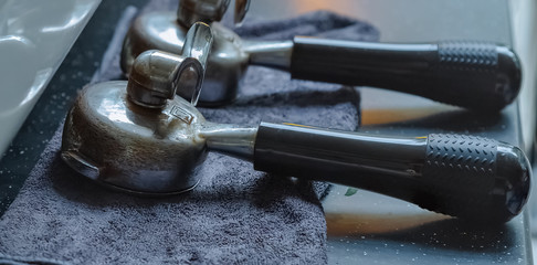 Marble Desktop. Blue cleaning cloth. Pair of coffee machine handles. Comparison of cold and warm colors. Warm light. Close-up lens