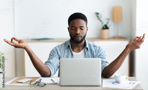 Fotomural Relaxed african american businessman meditating at office