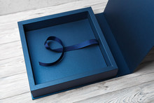 Stylish Square Cardboard Box For A Photo Album. Open Blue Cardboard Box For A Photo Book Open Box For Wedding Album On The Wooden Background.Gift Box With Lid.