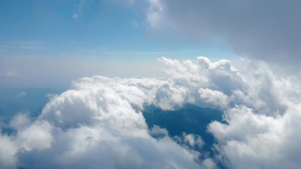 Wall Mural - Flying through amazingly beautiful cloudscape. Picturesque timelapse of white fluffy clouds moving softly on the clear blue sky in pure sunshine. Direct view from the cockpit.