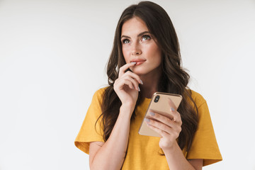 Sticker - Thoughtful young woman posing isolated over white wall background using mobile phone.