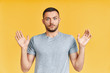 © GVS - Shocked young man with arms up looking amazed in camera over yellow background