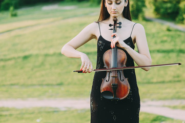 Wall Mural - beautiful girl with long hair plays the violin in the forest