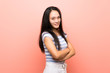 © luismolinero - Teenager asian girl over isolated pink background with arms crossed and looking forward