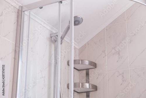 Fotografía Shower enclosure with shower head and shelf in domestic bathroom