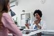 © lordn - Doctor talking with patient at desk in medical office. Health care concept, medical insurance. Womens health.
