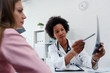 © lordn - Doctor talking with patient at desk in medical office. Health care concept, medical insurance. Womens health.
