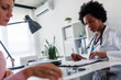 © lordn - Doctor talking with patient at desk in medical office. Health care concept, medical insurance. Womens health.