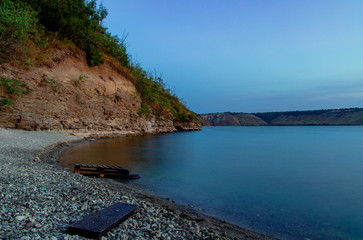 Wall Mural - evening twilight scenery landscape nature environment with narrow coast line space between smooth lake water surface and mountain 