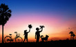 © khwanchai - Silhouete of kid dreams as pilot standing and holding airplane paper with friend running with wind turbine in sunset, imagination and freedom  idea concept