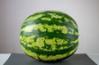 Big whole green striped watermelon on table