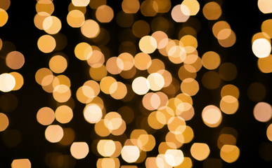 Wall Mural - christmas and holidays concept - blurred golden lights bokeh on black background