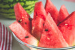 Triangular slices of ripe watermelon with red flesh and black seeds served on plate