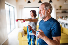 A Senior Couple Indoors At Home, Doing Exercise Indoors.