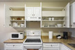 © Imagenet - Open cabinets and primary appliances on average home kitchen.