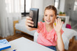 © Syda Productions - people, children and technology concept - girl with smartphone taking selfie at home