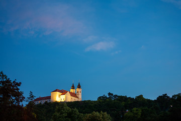 Poster - Tihany  abbey in yellow light at the blue hour in Tihany, at lake Balaton in Hungary