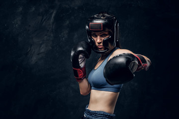 Portrait of attractive boxer in protective helmet and gloves ready to fight.