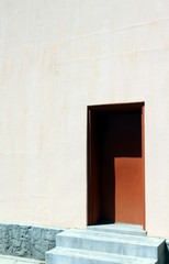 Wall Mural - Vertical shot of a white house with a brown door on a sunny day
