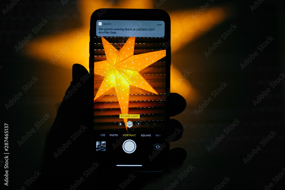PARIS, FRANCE - NOV 10, 2017: Studio light setting for the portrait mode in the new Apple iPhone x smartphone telephone - photographing a traditional nordig window star