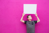 Fototapeta Nowy Jork - isolated cute boy holding blank white sign with space on colorful bright background