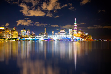 Fototapete - New York City skyline towards lower Manhattan Financial District at night with lights