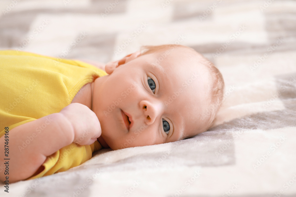 Cute little baby lying on bed