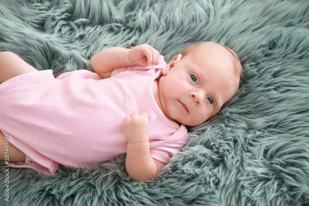 Cute little baby lying on bed