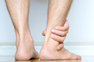 Picture of a male leg And the man's hand, he caught his ankle Pain in the ankle