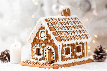 Homemade gingerbread house on a light background with bokeh, selective focus